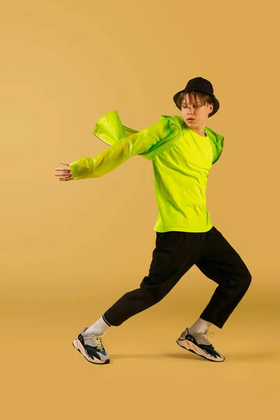 Old-school fashioned young man dancing isolated on yellow background