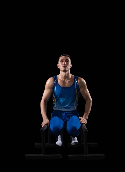 Musculaire mannelijke gymnastiektraining in de sportschool, flexibel en actief. Blanke fit man, atleet in blauwe sportkleding geïsoleerd op zwart — Stockfoto