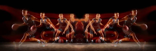 Jonge doelgerichte basketbalspeler training in actie geïsoleerd op zwarte achtergrond met vuur vlammen. Spiegel, stroboscoop lichteffect, reflectie — Stockfoto