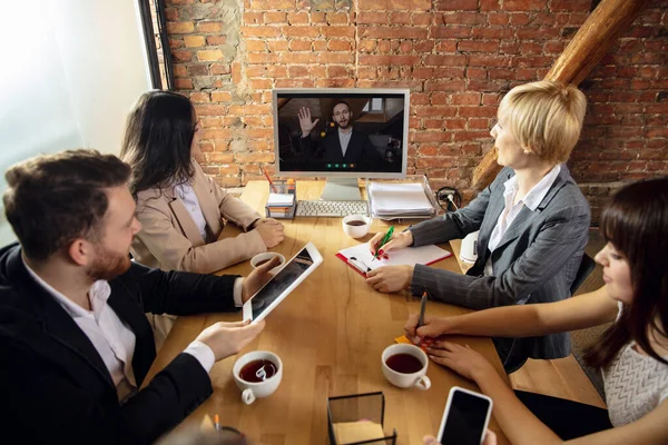 젊은 사람들이 사무실이나 거실에서 비디오 회의중에 이야기하고 일하는 모습 — 스톡 사진