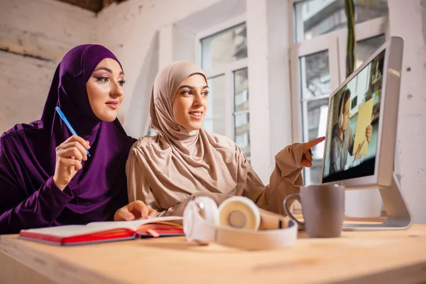 Felice due donne musulmane a casa durante la lezione, studiare vicino al computer, educazione online — Foto Stock