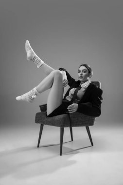 Ceket ve çorap giyen şık, genç bir bayan evde çalışıyor. Koronavirüs salgınının izolasyon nedeni sırasında moda.