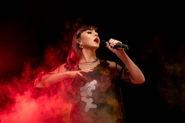 Portrait de chanteuse caucasienne isolé sur fond de studio sombre au néon — Photo