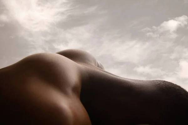 İnsan derisinin detaylı dokusu. Genç Afro-Amerikan erkek vücudunu yakından çek gökyüzü arkaplanlı manzara gibi. — Stok fotoğraf