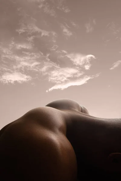 人間の皮膚の詳細な質感。空を背景にした風景のような若いアフリカ系アメリカ人男性の体のショットを閉じます — ストック写真