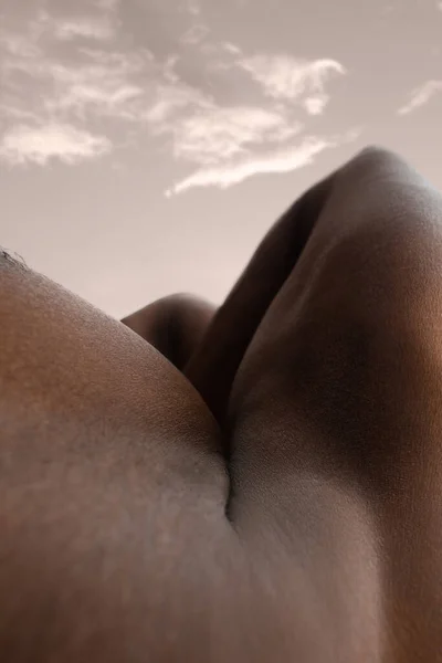 Detailed texture of human skin. Close up shot of young african-american male body like landscape with the sky background — Stock Photo, Image