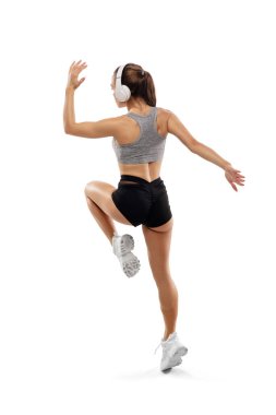 Beyaz stüdyo arka planında izole edilmiş beyaz kadın koşucu, atlet eğitimi. Reklam için kopyalama alanı.