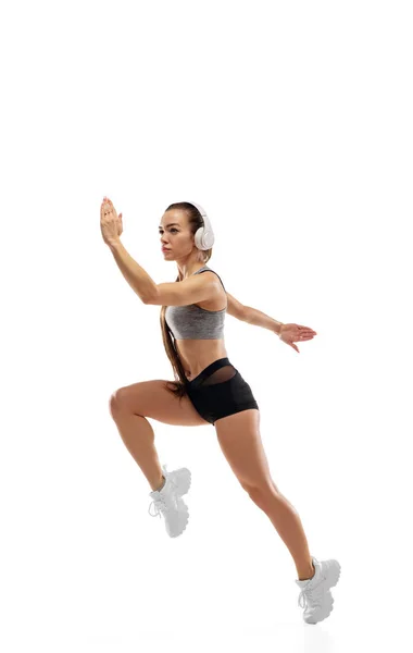 Corredor feminino profissional caucasiano, treinamento de atleta isolado em fundo de estúdio branco. Copyspace para anúncio. — Fotografia de Stock