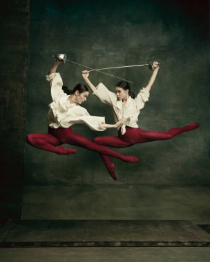 Two young female ballet dancers like duelists with swords. Ballet and contemporary choreography concept. Creative art photo. clipart