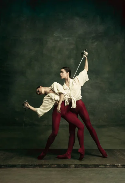 Dwie młode tancerki baletowe lubią pojedynki z mieczami. Balet i współczesna koncepcja choreografii. Kreatywne zdjęcie artystyczne. — Zdjęcie stockowe
