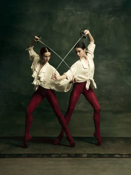 Duas jovens bailarinas gostam de duelistas com espadas. Balé e conceito de coreografia contemporânea. Foto de arte criativa. — Fotografia de Stock