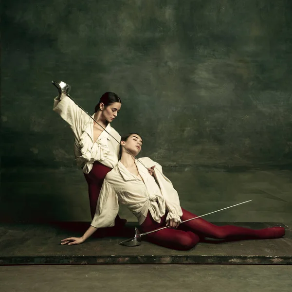 Δύο νεαρές χορεύτριες μπαλέτου γουστάρουν μονομάχους με σπαθιά. Μπαλέτο και σύγχρονη χορογραφία έννοια. Φωτογραφία δημιουργικής τέχνης. — Φωτογραφία Αρχείου