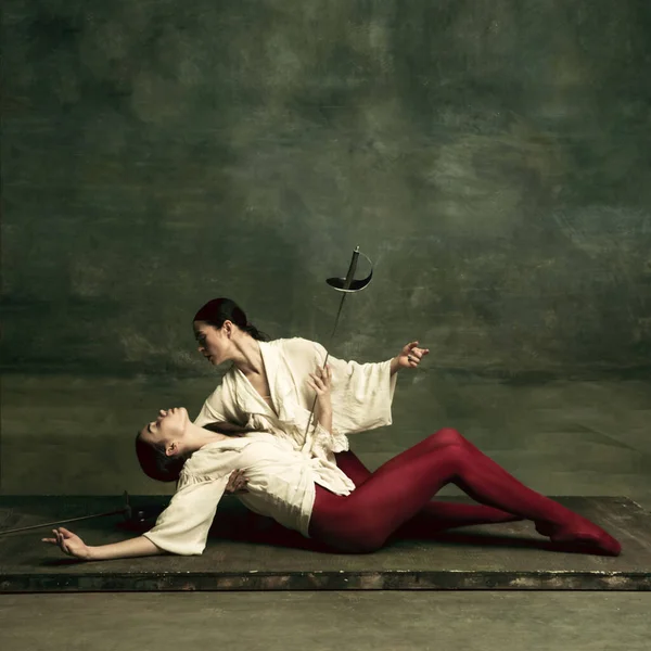 Zwei junge Balletttänzerinnen mögen Duellanten mit Schwertern. Ballett und zeitgenössisches Choreographie-Konzept. Kreatives Foto. — Stockfoto