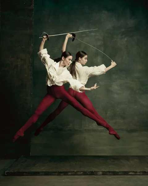 Duas jovens bailarinas gostam de duelistas com espadas. Balé e conceito de coreografia contemporânea. Foto de arte criativa. — Fotografia de Stock