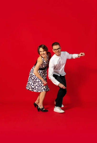 Velha escola moda jovem casal dançando isolado no fundo vermelho — Fotografia de Stock