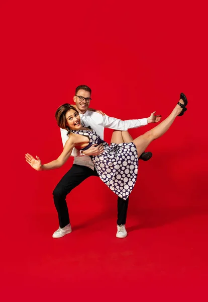 Vieja escuela de moda joven pareja bailando aislado sobre fondo rojo —  Fotos de Stock