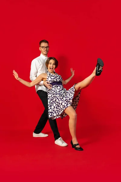 Gammeldags gammeldags unge par danser isoleret på rød baggrund - Stock-foto