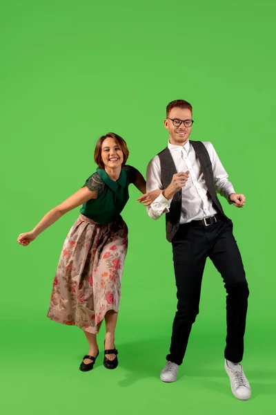 올드 스쿨 출신의 젊은 여성이 녹색 배경에 고립 된 채 춤을 추고 있습니다 — 스톡 사진