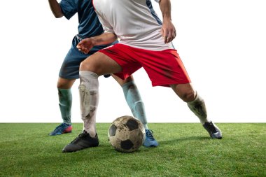 Profesyonel futbolun bacakları kapalı, futbol oyuncuları sahada top için savaşıyor, beyaz arka planda izole edilmiş.