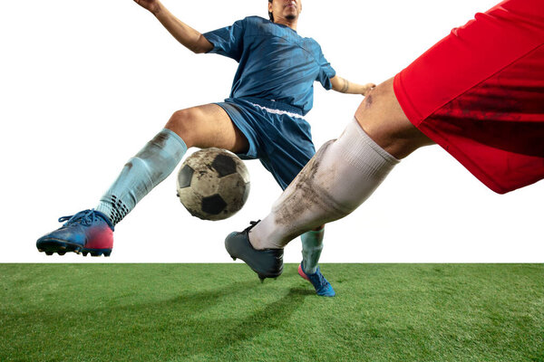 Close up legs of professional soccer, football players fighting for ball on field isolated on white background