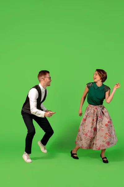 Ouderwetse jonge vrouw dansen geïsoleerd op groene achtergrond — Stockfoto