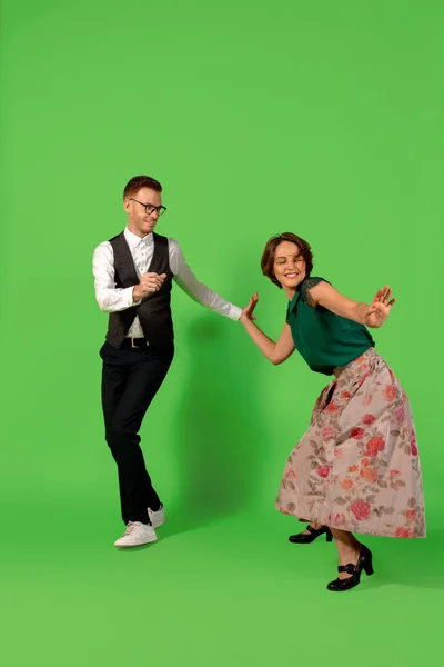 Ouderwetse jonge vrouw dansen geïsoleerd op groene achtergrond — Stockfoto