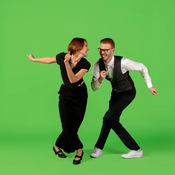 Old-school fashioned young woman dancing isolated on green background