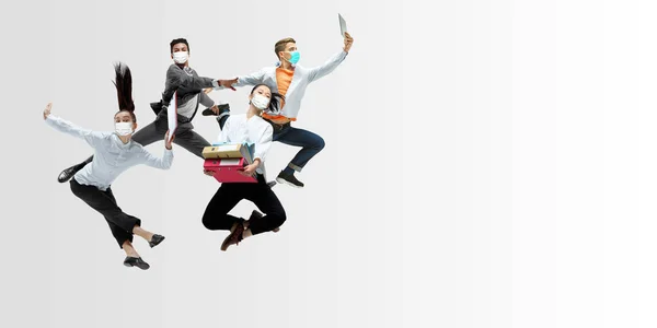 Glada kontorsarbetare i ansiktsmasker hoppar och dansar i avslappnade kläder eller kostym isolerad på studio bakgrund. Kreativt kollage. — Stockfoto