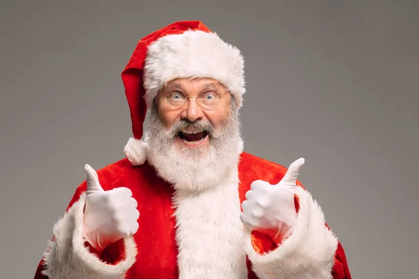 Senior man zoals de kerstman geïsoleerd op grijze studio achtergrond — Stockfoto