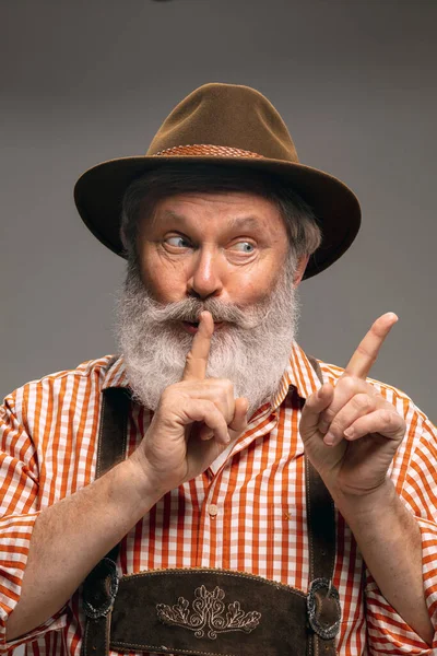 Szczęśliwy starszy mężczyzna ubrany w tradycyjny austriacki lub bawarski kostium gestykulując izolowane na szarym tle studio — Zdjęcie stockowe