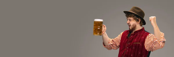 Happy smiling man dressed in traditional Austrian or Bavarian costume gesturing isolated on grey studio background — Stock Photo, Image