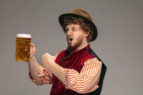 Felice uomo sorridente vestito in costume tradizionale austriaco o bavarese gesticolando isolato su sfondo grigio studio — Foto Stock