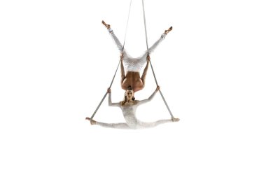 Couple of young acrobats, circus athletes isolated on white studio background. Training perfect balanced in flight