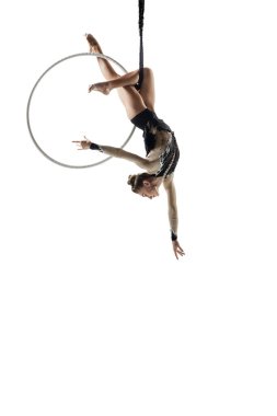Young female acrobat, circus athlete isolated on white studio background. Training perfect balanced in flight