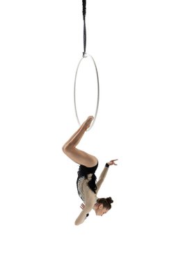Young female acrobat, circus athlete isolated on white studio background. Training perfect balanced in flight