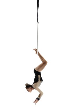 Young female acrobat, circus athlete isolated on white studio background. Training perfect balanced in flight
