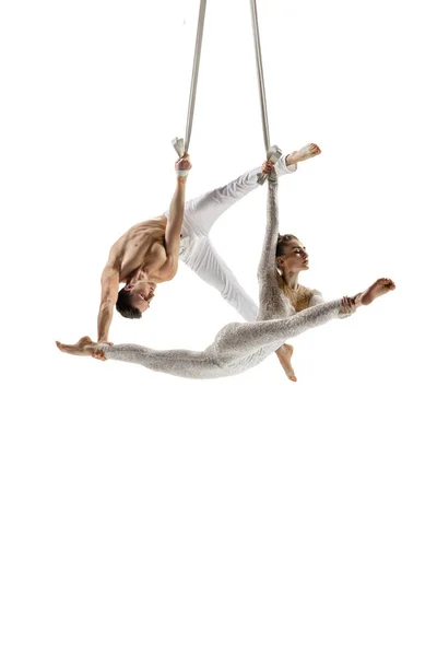 Couple of young acrobats, circus athletes isolated on white studio background. Training perfect balanced in flight — Stock Fotó