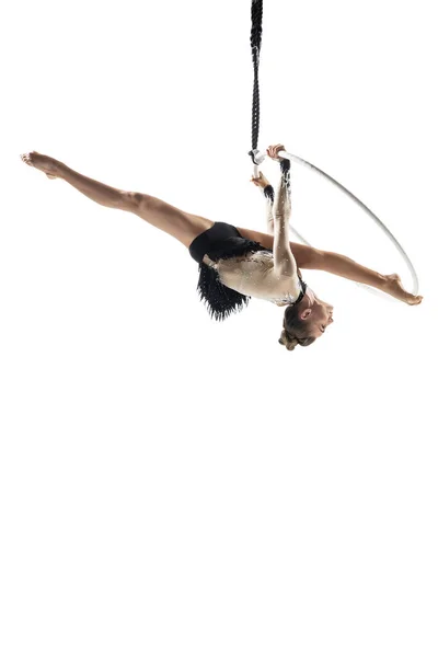 Young female acrobat, circus athlete isolated on white studio background. Training perfect balanced in flight — ストック写真