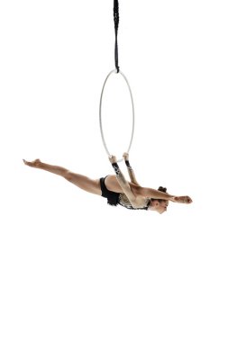 Young female acrobat, circus athlete isolated on white studio background. Training perfect balanced in flight