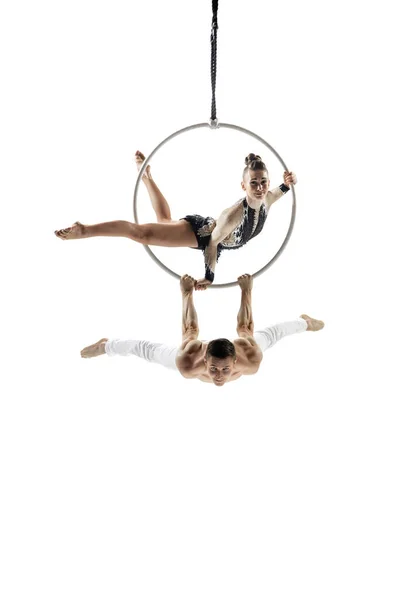 Couple of young acrobats, circus athletes isolated on white studio background. Training perfect balanced in flight — Stockfoto