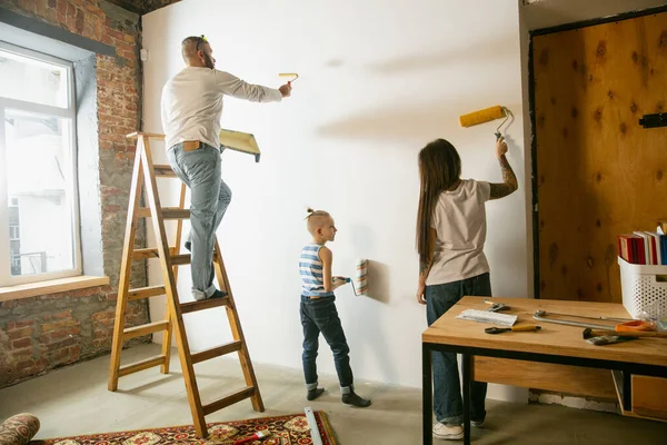 Mladá rodina si sama opravuje byt. Matka, otec a syn dělají doma člověka nebo renovaci — Stock fotografie