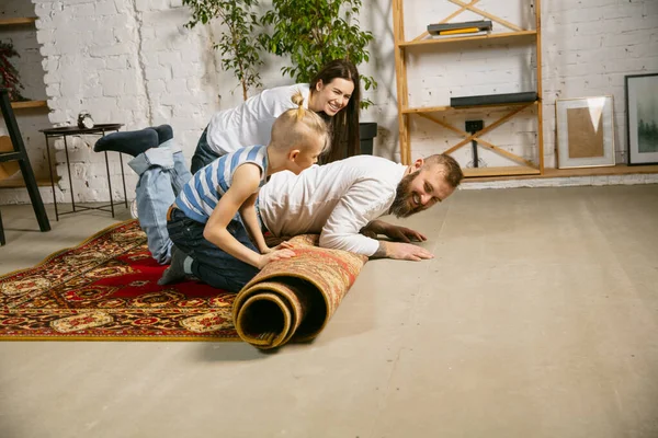 Joven familia haciendo reparaciones de apartamentos juntos. Madre, padre e hijo haciendo cambio de imagen o renovación en casa —  Fotos de Stock