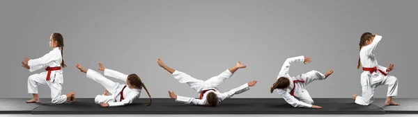 Young judo caucasian female fighter in white kimono with red belt in motion and action during training. Practicing martial arts fighting skills. — Stock Photo, Image