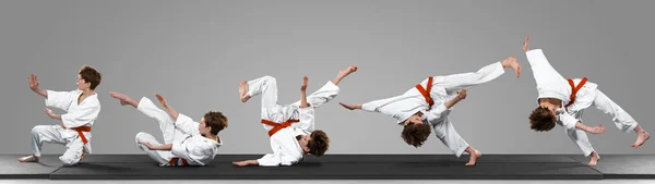 Young judo caucasian male fighter in white kimono with red belt in motion and action during training. Practicing martial arts fighting skills. — Stock Photo, Image