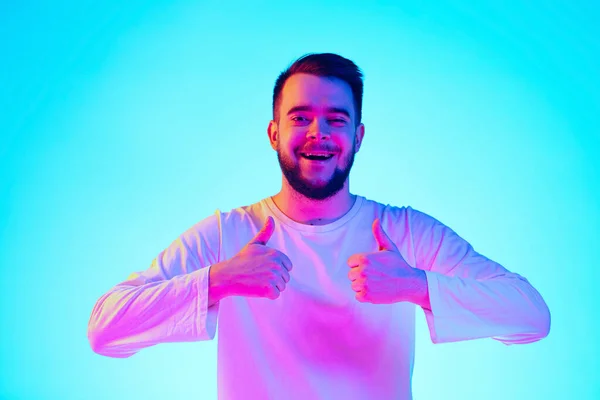 Portrait d'homme caucasien isolé sur fond de studio bleu au néon. Concept d'émotions humaines, expression faciale, ventes, publicité. — Photo