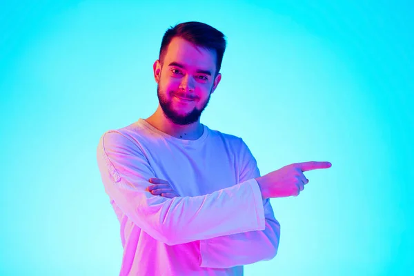 Portrait d'homme caucasien isolé sur fond de studio bleu au néon. Concept d'émotions humaines, expression faciale, ventes, publicité. — Photo