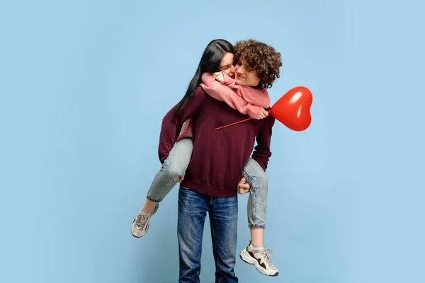 Beau couple amoureux sur fond bleu studio. Saint Valentin, concept amour et émotions — Photo