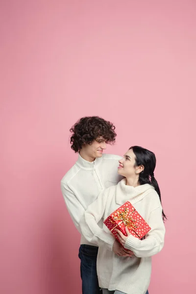 Joven, hermosa pareja enamorada en el fondo del estudio rosa. Día de San Valentín, concepto de amor y emociones —  Fotos de Stock