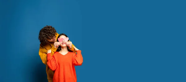 Jovem, belo casal apaixonado no fundo do estúdio azul. Dia dos Namorados, amor e emoções conceito — Fotografia de Stock