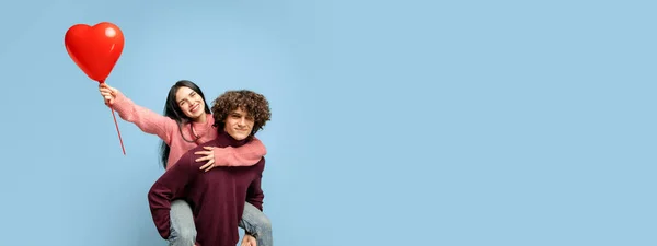 Young, beautiful couple in love on blue studio background. Valentines Day, love and emotions concept Stock Photo